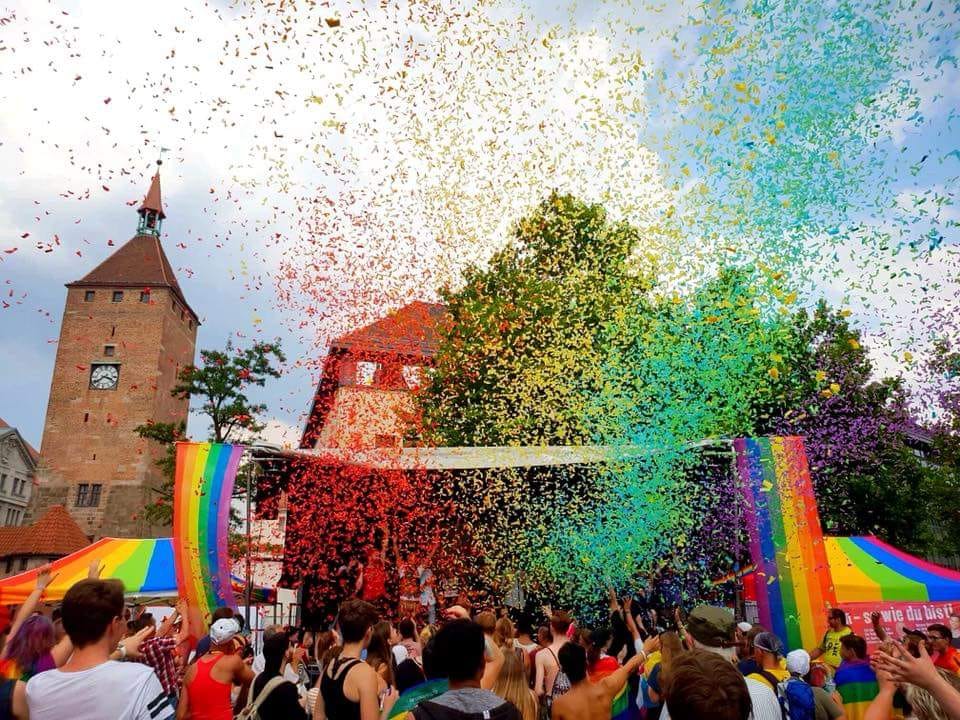 2018 Regenbogenfahnen und Confetti vor Kirchturm